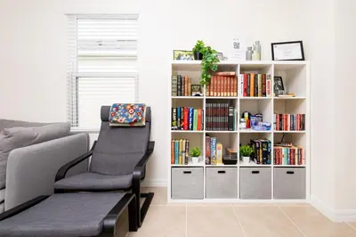 a living room with a book shelf with books at Entire House close to Disney in Orlando