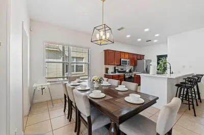a dining room and kitchen with a table and chairs at Enjoyable 6BR Home Near Disney in Orlando