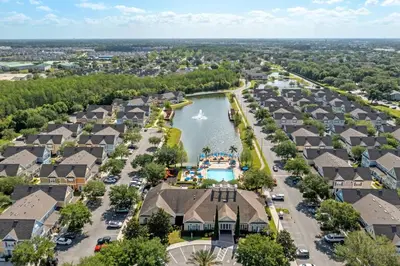 an aerial view of a town with houses and a lake at Mickey's Magical Townhome Venetian Bay Villages in Kissimmee