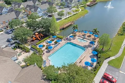 an overhead view of a swimming pool with blue umbrellas at Mickey's Magical Townhome Venetian Bay Villages in Kissimmee