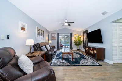 a living room with a couch and a flat screen tv at Private Paradise! Stunning south-facing pool home in Kissimmee