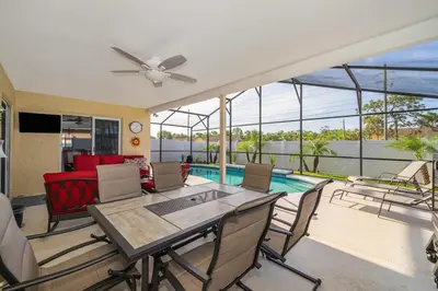 a living room with a table and chairs and a pool at Private Paradise! Stunning south-facing pool home in Kissimmee