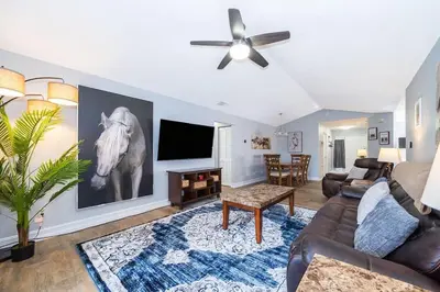 a living room with a couch and a tv at Private Paradise! Stunning south-facing pool home in Kissimmee