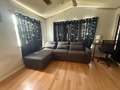 a living room with a couch in front of a window at Sherwood Forest Mobile Home in Kissimmee