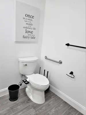 a bathroom with a toilet and a poster on the wall at The Villas at Seven Dwarfs - 2624 Mickey Villa - Near Disney - Water Park in Kissimmee