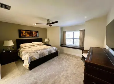 a bedroom with a bed and a ceiling fan at Stunning Ventura Condo in Orlando