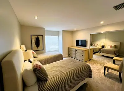 a bedroom with two beds and a mirror at Stunning Ventura Condo in Orlando