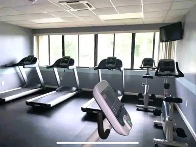 a gym with a bunch of cardio machines in it at Ventura Village Cottage Grove Townhome in Orlando