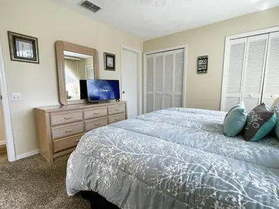 a bedroom with a bed and a flat screen tv at Ventura Village Cottage Grove Townhome in Orlando