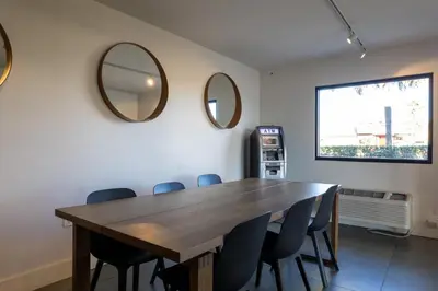a dining room with a table and mirrors on the wall at Impeccably cozy hotel room Developer Inn Express in Kissimmee