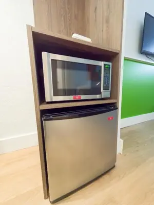 a microwave oven sitting on top of a refrigerator at Impeccably cozy hotel room Developer Inn Express in Kissimmee