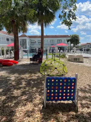 a playground in a park with a seesaw at Impeccably cozy hotel room Developer Inn Express in Kissimmee