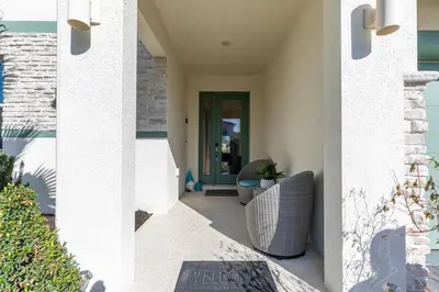 a porch of a house with a chair and a plant at Beautiful and cozy home at Sonoma Resort in Kissimmee