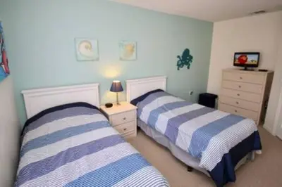 two beds in a bedroom with blue and white stripes at Perfect vacation Gated Resort with Private Pool in Kissimmee