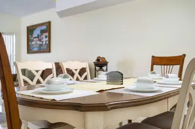 a dining room table with white dishes on it at Spacious Bright Close to Disney with Pool and Gym in Kissimmee