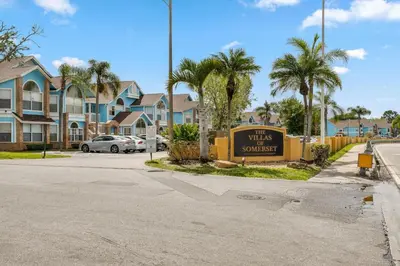 a sign for a villas with palm trees and houses at Spacious Bright Close to Disney with Pool and Gym in Kissimmee
