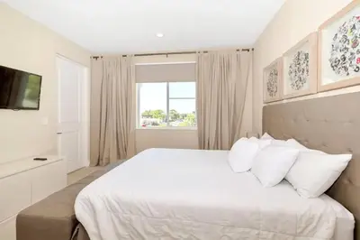 a white bedroom with a large bed and a window at Snow White Home Disney (53360775) in Orlando