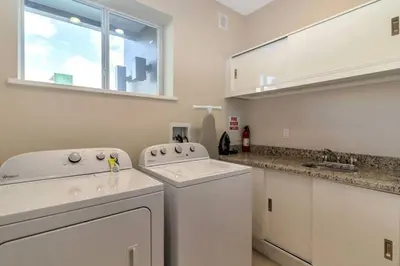 a white laundry room with a washer and dryer at wish home disney (45437492) in Orlando