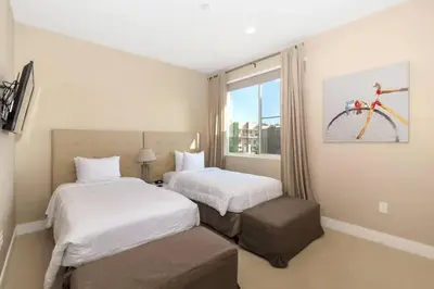 a hotel room with two beds and a bike on the wall at Disney Dream Home (7662508) in Orlando