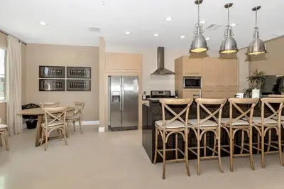 a kitchen with a table and a stainless steel refrigerator at Disney Dream Home (7662508) in Orlando