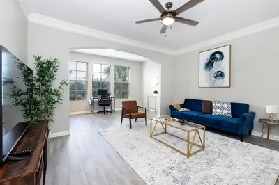 a living room with a blue couch and a ceiling fan at Cozy Escape - Disney Universal SeaWorld in Orlando