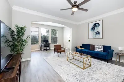 a living room with a blue couch and a table at Cozy Escape - Disney Universal SeaWorld in Orlando