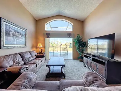a living room with a couch and a flat screen tv at Four Bed in Emerald Island Resort mins to Disney in Kissimmee
