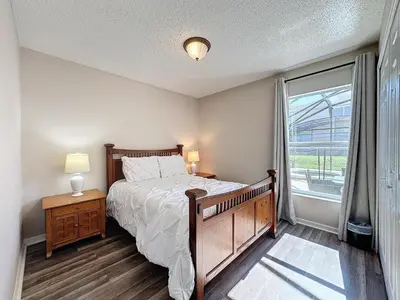 a bedroom with a bed and a large window at Five Star Home Private Pool & Jaccuzzi*Free Wi-Fi* in Kissimmee