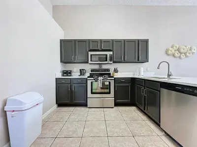 a kitchen with black cabinets and a stove at Five Star Home Private Pool & Jaccuzzi*Free Wi-Fi* in Kissimmee