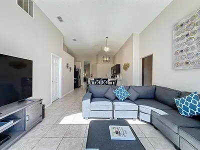 a living room with a couch and a flat screen tv at Five Star Home Private Pool & Jaccuzzi*Free Wi-Fi* in Kissimmee