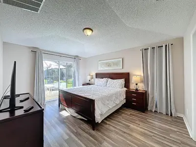 a bedroom with a bed and a television in it at Five Star Home Private Pool & Jaccuzzi*Free Wi-Fi* in Kissimmee