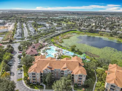 an aerial view of a resort with a pool and a lake at Two Miles Disney Pool Water Park & Water slide in Orlando