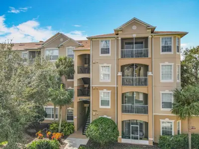 an apartment building with trees in front of it at Two Miles Disney Pool Water Park & Water slide in Orlando