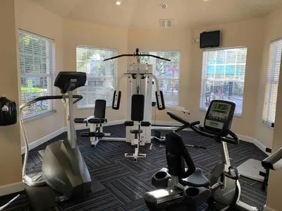 a gym with treadmills and exercise bikes in a room at 4 bed Single Level Home in Windsor Palms Sleeps 8 in Kissimmee