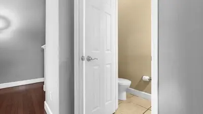 a bathroom with a toilet and a white door at Sunny Summer Stay - Renovated TownHome by Disney! in Orlando