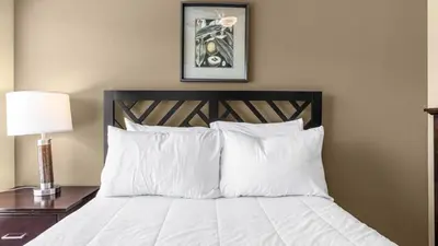 a bed with white pillows and a picture on the wall at Sunny Summer Stay - Renovated TownHome by Disney! in Orlando