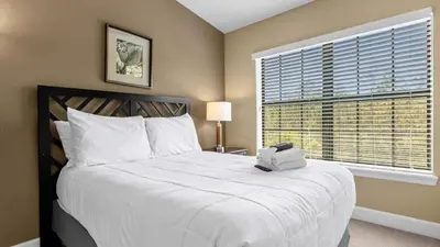 a bedroom with a large white bed with a window at Sunny Summer Stay - Renovated TownHome by Disney! in Orlando