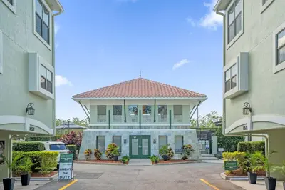 a building in a parking lot between two buildings at Sunny Summer Stay - Renovated TownHome by Disney! in Orlando