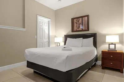 a bedroom with a bed with two night stands and two lamps at Sunny Summer in FL - Relax in a TownHome by Disney! in Orlando