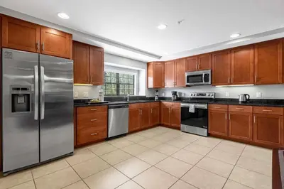 a kitchen with wooden cabinets and stainless steel appliances at Sunny Summer in FL - Relax in a TownHome by Disney! in Orlando