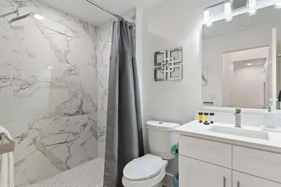a white bathroom with a shower and a toilet and a sink at Allure - Sleeps 8 - 3 BDM - Disney in Kissimmee