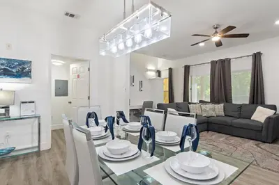 a dining room and living room with a glass table at Allure - Sleeps 8 - 3 BDM - Disney in Kissimmee