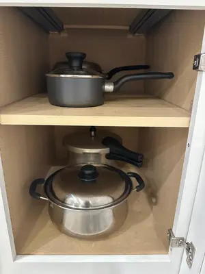 a pot and a pan on a shelf in a drawer at 4br Disney Retreat Gated Resort with Pool & Hot Tub in Orlando