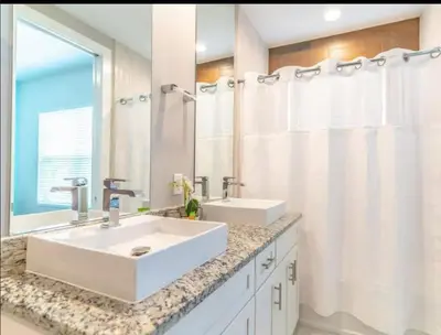 a white bathroom with a sink and a mirror at 4br Disney Retreat Gated Resort with Pool & Hot Tub in Orlando