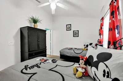 a bedroom with a bed with a mickey mouse headboard at The Sunny Nest in Orlando
