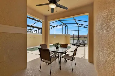 a dining room with a table and chairs and windows at Paradise Pines Villa in Orlando