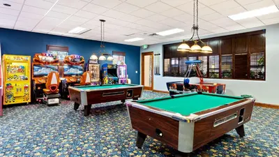 a room with two pool tables and arcade games at Paradise Pines Villa in Orlando