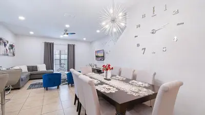 a dining room and living room with a table and chairs at Paradise Pines Villa in Orlando