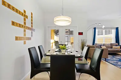 a dining room and living room with a table and chairs at 8953 Candy Palm Road in Kissimmee