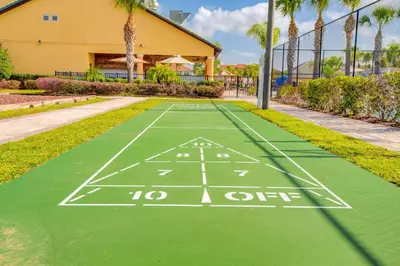 a green tennis court with a yard line at 8953 Candy Palm Road in Kissimmee
